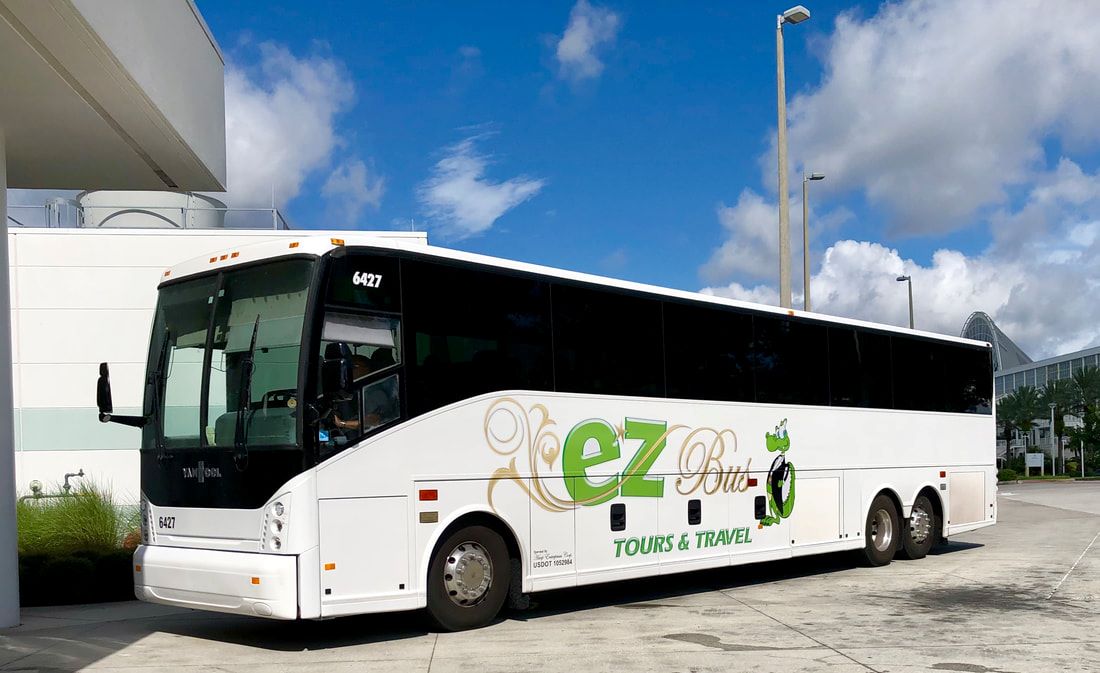 Side view of bus with EZ Bus Tours & Travel logo which has a gator wearing a tuxedo next to the name